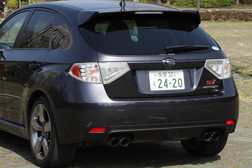 ブリスターフェンダーによるボリューム感はリアから見ても迫力満点。バンパーは下部をディフューザー形状とした専用パーツ。テールランプはノーマルモデルと同じだが、ガーニッシュ部分はボディー同色で引き締まったイメージに。マフラーも専用の大型サイレンサーを採用したツイン＆デュアルテールパイプタイプとなる