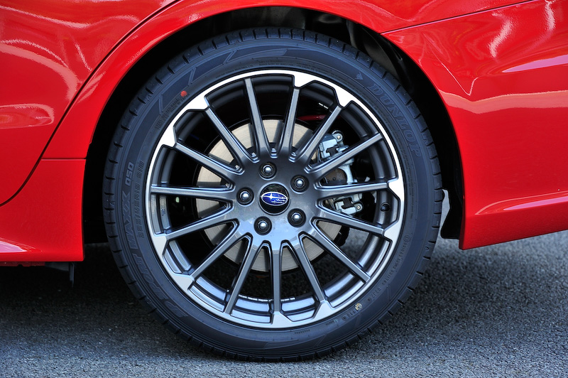 ピュアレッドカラーの「1.6STI Sport EyeSight」。ボディサイズは4690×1780×1490mm（全長×全幅×全高）、ホイールベース2650mm。エクステリアでは専用設計のフロントバンパーやフロントグリル、LEDフロントフォグランプ、大型デュアルマフラーカッター、STIオーナメント（フロント/リア）などを装着。足下は専用デザインの18インチアルミホイール（ダークグレー＋切削光輝）にダンロップ「SP SPORT MAXX 050」（225/45 R18）を組み合わせる