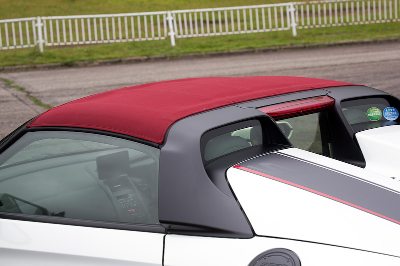 ルーフ部の布色がボルドーレッドになっているModulo仕様のロールトップ（12万9600円）。純正ロールトップと使い勝手は同様。アルミ製ブラック塗装でS660ロゴ入りのフューエルリッドは2万4840円。貼り付けではなく純正のフューエルリッドを外しての装着