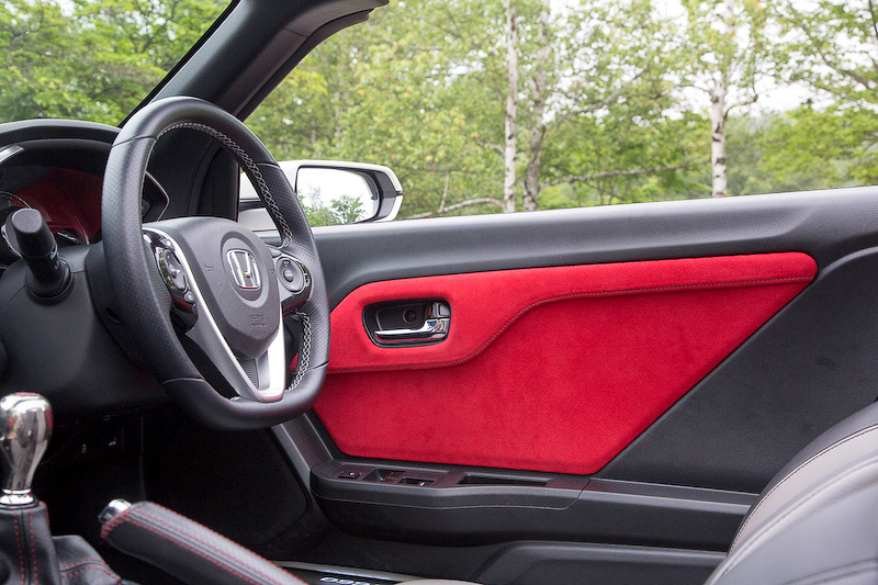 スエード生地のドアライニングパネル。カラーは写真のレッド×ダークグレーステッチのほかに、グレー×ダークグレーステッチ、ブラック×グレーステッチがある。価格は左右セットで3万240円。チタン製シフトノブとシフトブーツセットは2万5380円。シフトブーツはブラック×レッドステッチとブラック×グレーステッチが用意される