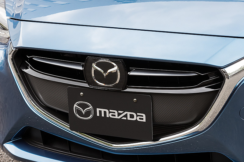マツダ・レーダー・クルーズ・コントロールの装着によりグリル形状を若干変更。従来ディーゼル車ではグリルガーニッシュに赤い差し色が入っていたが、今回の改良によりグレーメタリックに変更された