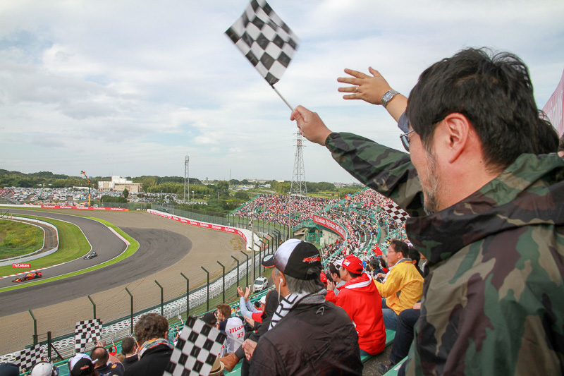 ゴール！　ウィニングランのフォーミュラカーにチェッカー（無料で配布されている）を振る！