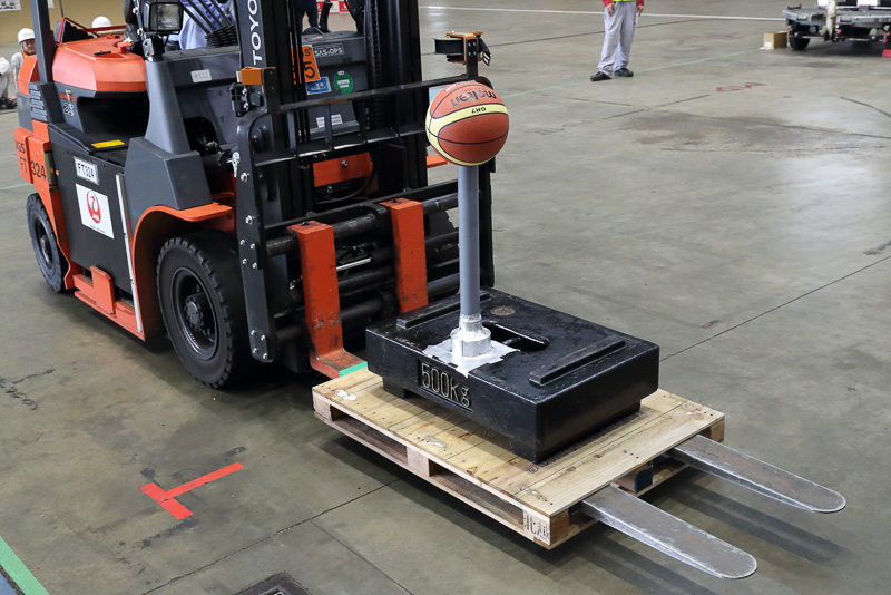荷物は500kgのウエイトとポールの上に乗ったバスケットボール