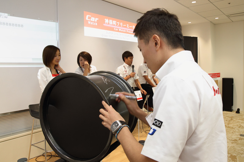 会場にはホンダアクセスが提供しているモデューロブランドのレーシングホイールが展示され、トークショー後に牧野選手がサインを書き入れていた
