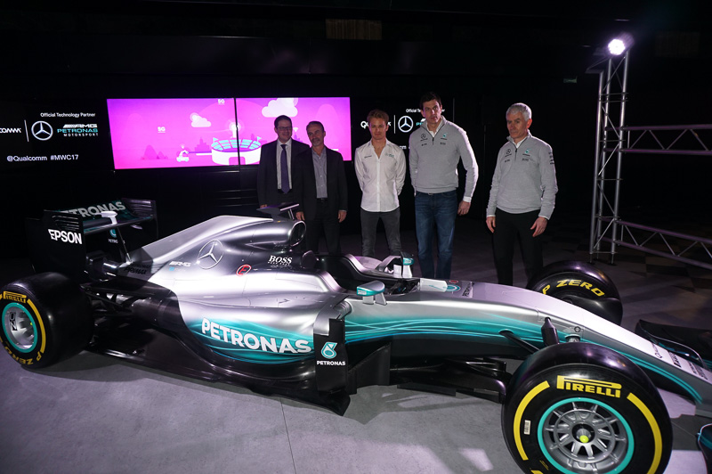 展示されたショーカーと記念撮影するQualcomm Technologies 社長 クリスチアーノ・アーモン氏、Qualcomm Technologies 上席副社長 兼 オートモーティブ事業部 事業本部長 パトリック・リトル氏、2016年F1ワールドチャンピオンのニコ・ロズベルグ氏、メルセデスF1チーム 代表 トト・ウォルフ氏、メルセデスF1チーム テクノロジーディレクター ジェフ・ウィリス氏（左から右へ）