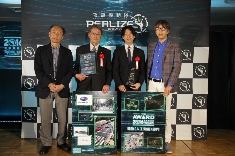 電脳（人工知能）部門グランプリを受賞した富士重工業株式会社と日本アイ・ビー・エム株式会社。富士重工業株式会社 スバル第一技術本部 車両研究実験第四部 部長 樋渡穣氏（中央左）と、日本アイ・ビー・エム株式会社 グローバル・ビジネス・サービス事業本部 IoTソリューション アプリケーション・アーキテクト 宮坂浩司氏（中央右）