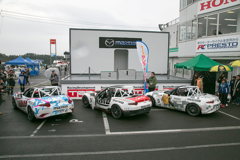 日本初開催のGLOBAL MX-5 CUP表彰式。優勝は7号車の山野哲也選手(CABANA Racing)、2位は56号車 大井貴之選手(Team“Be a racing driver”)、3位は5号車 今村大輔選手(KIMInternational)。優勝した山野選手は暫定表彰式で「イコールコンディションが整っているレースだけに、とても楽しく走れました。今村選手とのバトルも楽しかったし、大井さんを抑え切るのも楽しかったです。途中から雨になりましたが、降り始めはドライのラインを走っていました。しかし雨量が増えてきてからは少しずつ探りながらラインを変えて走り切りました」と感想を語った