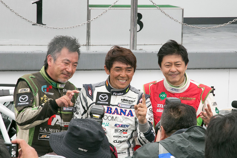 日本初開催のGLOBAL MX-5 CUP表彰式。優勝は7号車の山野哲也選手(CABANA Racing)、2位は56号車 大井貴之選手(Team“Be a racing driver”)、3位は5号車 今村大輔選手(KIMInternational)。優勝した山野選手は暫定表彰式で「イコールコンディションが整っているレースだけに、とても楽しく走れました。今村選手とのバトルも楽しかったし、大井さんを抑え切るのも楽しかったです。途中から雨になりましたが、降り始めはドライのラインを走っていました。しかし雨量が増えてきてからは少しずつ探りながらラインを変えて走り切りました」と感想を語った