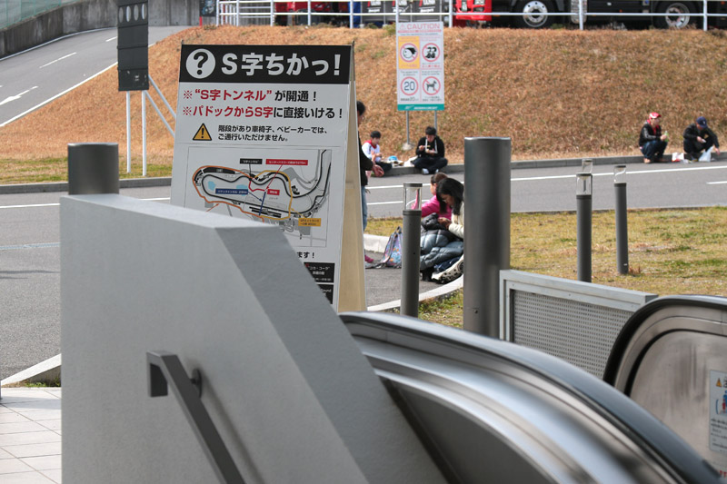 「S字ちかっ！」の看板は、パドックトンネルを抜け、エスカレーターで地上に出ると目の前にある