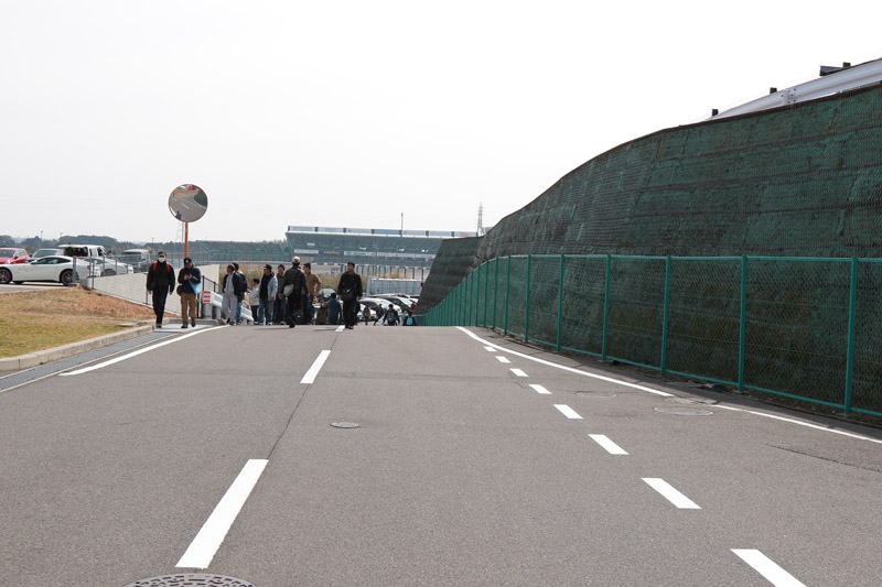 パドック内のメイン道路をS字方面に進む。遠くに2コーナーのB席スタンドが見える