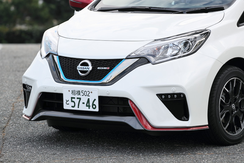 ノート e-POWER NISMOのエクステリアでは専用のフロントグリル、リアバンパー(リアフォグランプ付)、ルーフスポイラー、サイドシルプロテクター、LEDハイパーデイライト(車幅灯連動)、シャークフィンアンテナを装備。また、NISMO仕様らしくフロントクロスバー、フロントサスペンションメンバーステー(トンネルステー)、トンネルステー、リアサスペンションメンバーステー、リアクロスバーなどでボディ補強を行なうとともに、専用チューニングコンピューター(VCM)を搭載して独自のアクセルレスポンスや回生力を実現。足下は16インチアルミホイールに横浜ゴム「DNA S.drive」(195/55 R16)を組み合わせる
