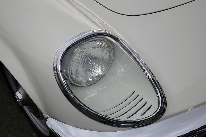 ヘッドライトカバーの内側には、外気を入れて曇りが出ないようにするスリットがある。エンブレムは輸出用の110S。フェンダーにあるスリットはエンジンルームの熱気抜き