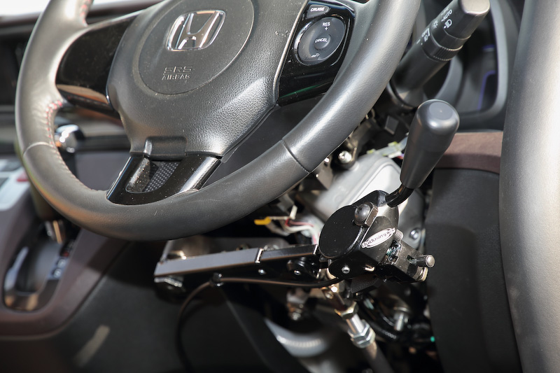 下肢障害者の運転をサポートするハンドドライブ装置装着車のブースには青木拓磨選手の姿も