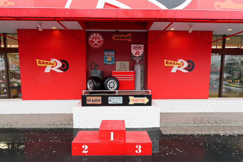赤い外壁と表彰台が目印の「GARAGE R」