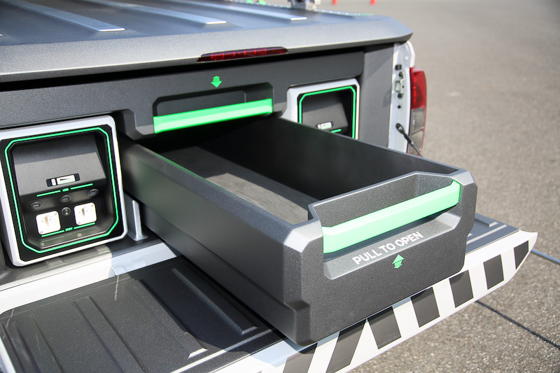 荷台スペースのトレイにはレスキュー時に用いるロープや斧といった工具が入れられるほか、荷台の横にはドローンを収納できるスペース（ドローンの絵が書かれている）も。エンジンは190PSを発する2.3リッターツインターボディーゼルで、車高は専用サスペンションにより50mm引き上げられ、悪路走破性を高めている