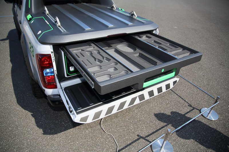 荷台スペースのトレイにはレスキュー時に用いるロープや斧といった工具が入れられるほか、荷台の横にはドローンを収納できるスペース（ドローンの絵が書かれている）も。エンジンは190PSを発する2.3リッターツインターボディーゼルで、車高は専用サスペンションにより50mm引き上げられ、悪路走破性を高めている