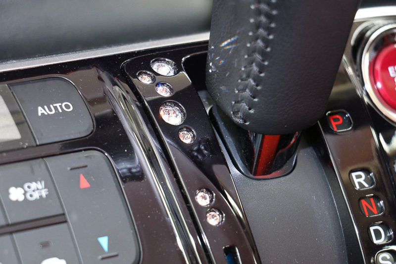 インパネにはホンダアクセスが純正用品としてラインアップしている「ドリンクホルダーリング」（1万2960円）や「インテリアデコレーション（シフトゲートカバー）」（7020円）を装着。光を反射するスワロフスキー・クリスタルがアクセントとなっている