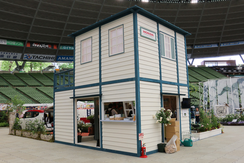 ブースのグランドデザインはガーデナーの伊藤きみえ氏が監修。家屋の施工はツインリンクもてぎの自然体験施設「ハローウッズ」が担当し、モルタル造形による外壁や門柱は空間デザイナーの富澤一信氏が手掛けた