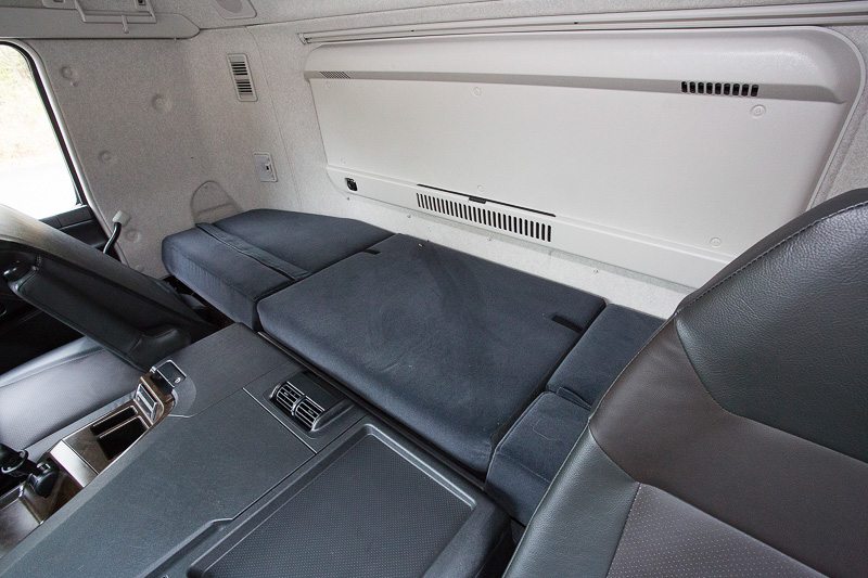 標準キャブにはシート後方に仮眠用のベッドがある。仮眠時はカーテンでコクピットと仕切るので夏場にエアコンの冷気が仮眠スペースに届きにくくなることから、オプションで蓄冷式リアクーラーも用意されている