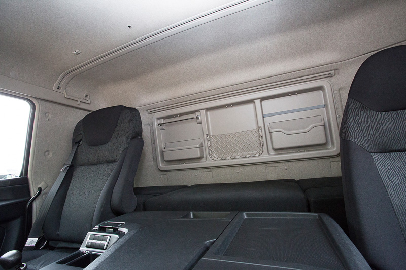 標準キャブにはシート後方に仮眠用のベッドがある。仮眠時はカーテンでコクピットと仕切るので夏場にエアコンの冷気が仮眠スペースに届きにくくなることから、オプションで蓄冷式リアクーラーも用意されている