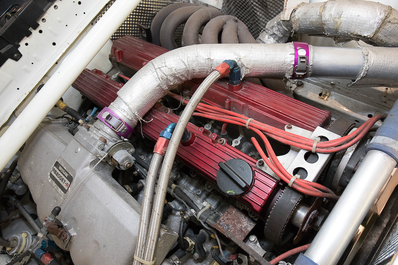 国内のクルマと大きく違うのは点火系。ダイレクトイグニッションではなくディストリビューターを使う点火方式になっている。そのため、RB20DETエンジンながらディストリビューター、プラグコードと点火コイルが付いている