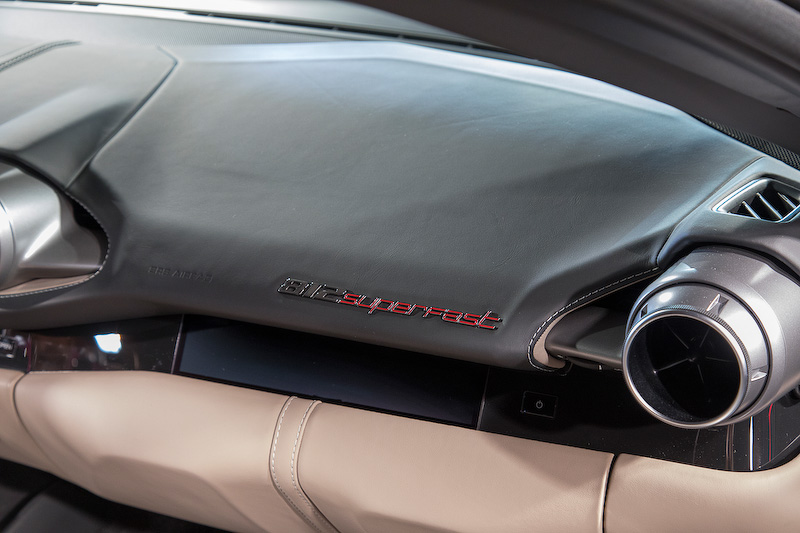 センターのエアコン吹き出し口のデザインも独特。助手席側に812 SuperFastのエンブレムが付く。そしてフロントエンジンなのでリアには大きめのケースとカバンがそれぞれ2つ載るほどのトランクスペースがある