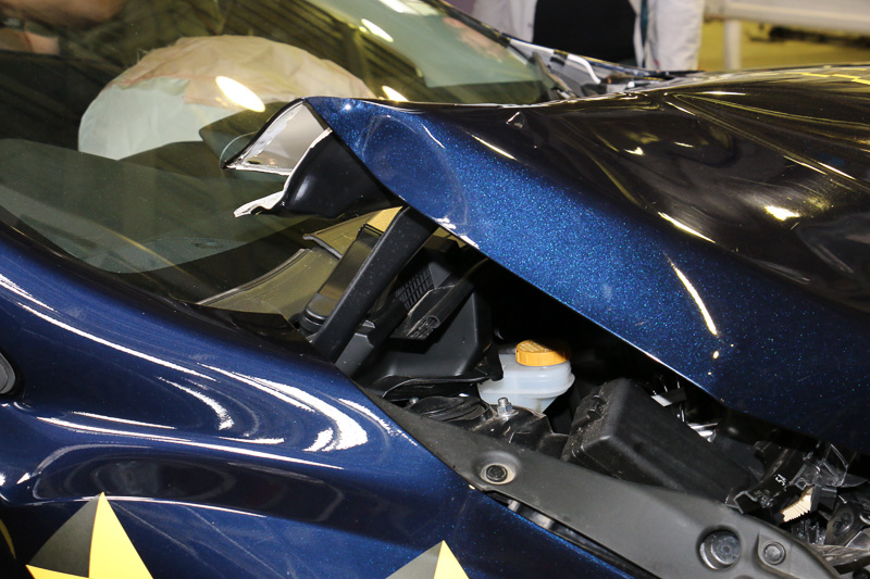 衝突後もドアが開くこと、ボンネットがヒンジ部分で山折りになってフロントウィンドウに刺さらないようになっていることなどを解説