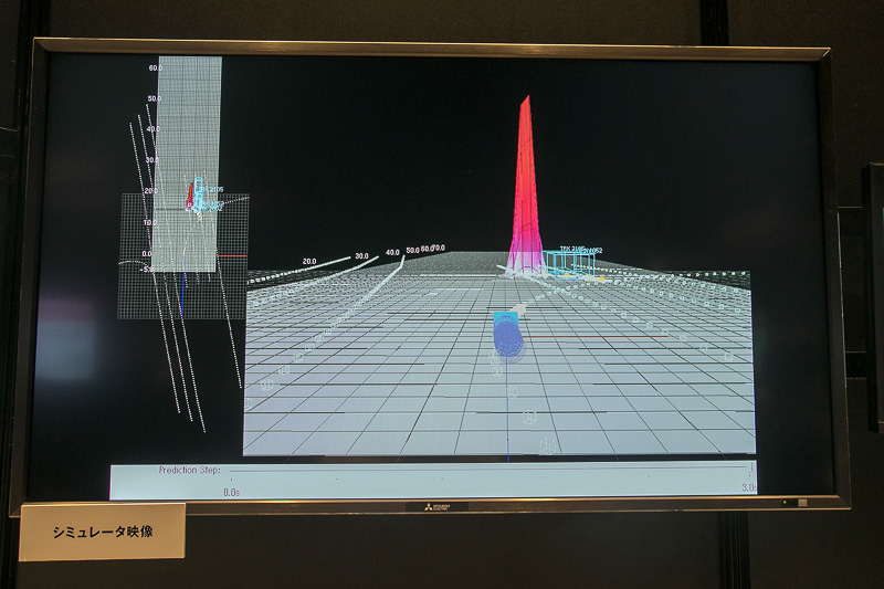 シミュレーターの映像。右折車側の視点で自車が進む予定が点線で表現されている。想定進路に対して直進車が来ているので停止しているが、データには直進車の後方に赤く飛び出た印がある。これが車両間通信によって得たバイクの存在を示す表示