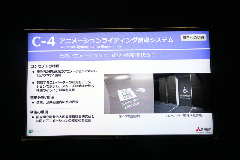 2016年は駐車場内の案内表示などで紹介していたアニメーションライティング誘導システムを、今年はビルなどの案内表示に使って展示。エレベーターのセットが用意され、内部の状況をカメラで把握して、エレベーター内に車いす利用者がいるという設定。エレベーターが目的階に到着する前に、扉にアニメーションを投影して車いす利用者が降りることを表示。その後、出入り口の空けてほしいスペースを表示することで、エレベーター利用者がスムーズの乗り降りできるようにするというデモ内容。投影にはプロジェクターを使用している