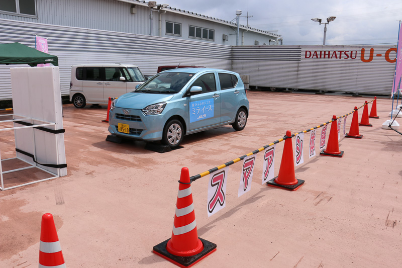スマートアシストIIIを搭載したミラ イースを使い、小型ステレオカメラによる「誤発進抑制制御機能」を体験。運転席に座る解説員がアクセルを全開にしても、ゆっくりと輪留めを上っていくという出力制限の様子や、システムの作動で警報音が鳴る状況を車内で体験し、希望者は実際に運転席に座ってアクセル全開にもトライできた