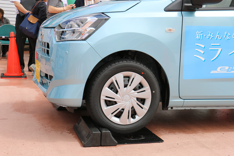 スマートアシストIIIを搭載したミラ イースを使い、小型ステレオカメラによる「誤発進抑制制御機能」を体験。運転席に座る解説員がアクセルを全開にしても、ゆっくりと輪留めを上っていくという出力制限の様子や、システムの作動で警報音が鳴る状況を車内で体験し、希望者は実際に運転席に座ってアクセル全開にもトライできた