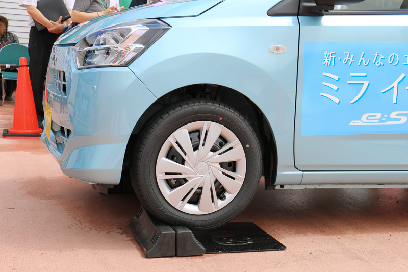 スマートアシストIIIを搭載したミラ イースを使い、小型ステレオカメラによる「誤発進抑制制御機能」を体験。運転席に座る解説員がアクセルを全開にしても、ゆっくりと輪留めを上っていくという出力制限の様子や、システムの作動で警報音が鳴る状況を車内で体験し、希望者は実際に運転席に座ってアクセル全開にもトライできた