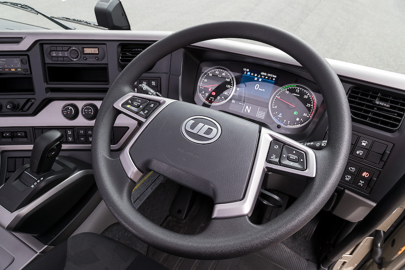 新型クオンではコクピットまわりのデザインを刷新し、使いやすいストレート式のシフトパターンを採用。また、クルーズコントロールの操作が行なえるスイッチを4本スポークステアリングに備えたほか、視認性に優れたインパネなどを採用。さらに省燃費運転をアドバイスしてくれる「燃費コーチ」といった機能も備わる