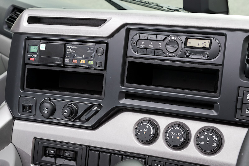 新型クオンではコクピットまわりのデザインを刷新し、使いやすいストレート式のシフトパターンを採用。また、クルーズコントロールの操作が行なえるスイッチを4本スポークステアリングに備えたほか、視認性に優れたインパネなどを採用。さらに省燃費運転をアドバイスしてくれる「燃費コーチ」といった機能も備わる