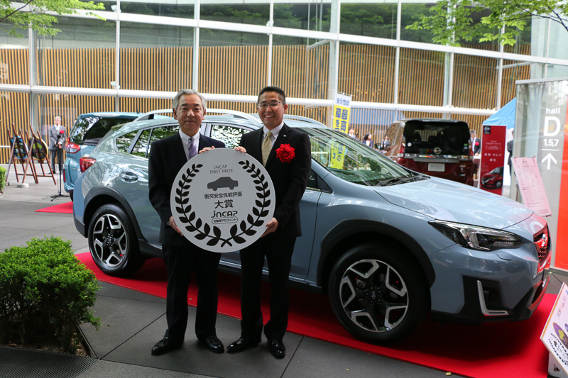 自動車事故対策機構 理事長の濱隆司氏（写真左）より特別賞の大型メダルを手渡された株式会社スバルの井上氏（写真右）