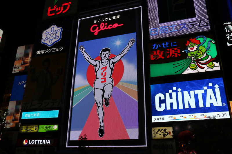 日没後に点灯したあとも、グリコサインはしばらく通常の演出を実施。2014年から6代目にリニューアルした現在のグリコサインは14万個のLEDを照明に使っており、ゴールを駆け抜けていたり、時間帯が朝から夜に移り変わるといったアニメーションを披露している