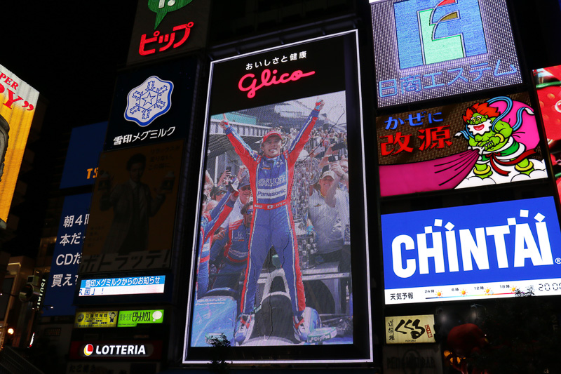 スペシャルメッセージの公開では、グリコサインが徐々に暗転しながら、佐藤琢磨選手に入れ替わった