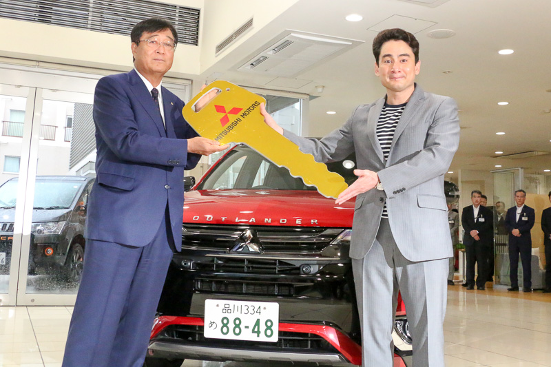 三菱自動車工業 代表取締役社長兼CEO 益子修氏からゴールデンキーを手渡される野口健氏