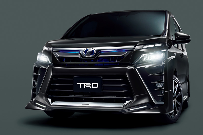 新型ヴォクシーの「HYBRID ZS」「ZS」に対応するフロントスポイラー（LED付）、リアバンパースポイラー、サイドガーニッシュをセットにした「エアロパーツセット」（塗装済：税別12万円、素地：税別11万2000円）と、「フロントグリル（LED付）」（塗装済：税別8万円、素地：税別7万6000円）などを装着した車両