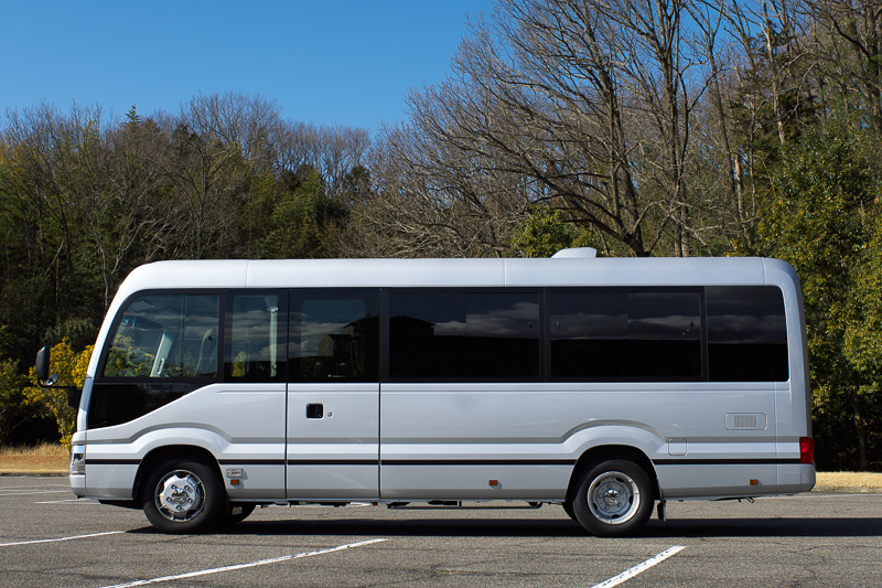 新型コースター。試乗車はEX/ロングボディ/ハイルーフ/29人乗り/6速AT仕様。ボディサイズは6990×2080×2635mm（全長×全幅×全高）