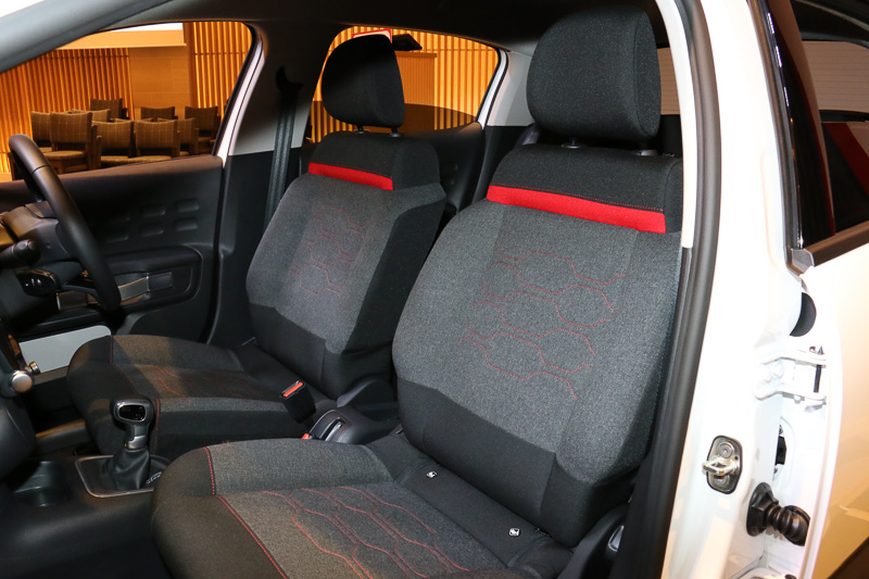 C3 シャインのシートには、肩口にレッドにラインをアクセントに使うファブリック表皮を採用。柔らかいインナーフォームを組み合わせることで快適性とサポート性を両立する