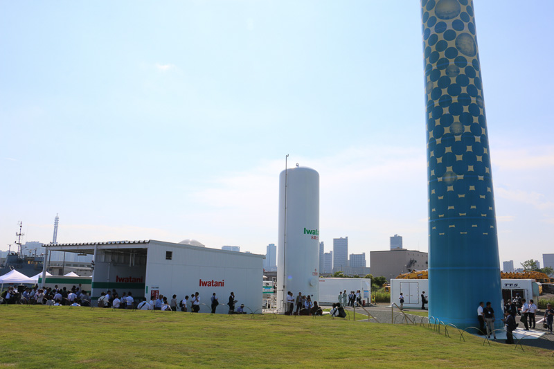 現地取材会中のハマウィング。写真内の右手にあるブルーの支柱がハマウィングになるが、ローター直径（80m）まで含めて118mという巨大なハマウィングは敷地内からは写真に収まりきらない