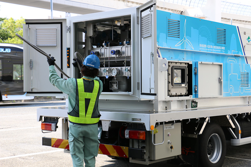 簡易水素充填車のハッチ内に収納されている充填ホースをFCフォークリフトに接続