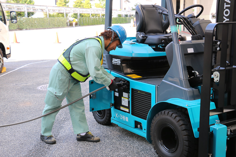 簡易水素充填車のハッチ内に収納されている充填ホースをFCフォークリフトに接続