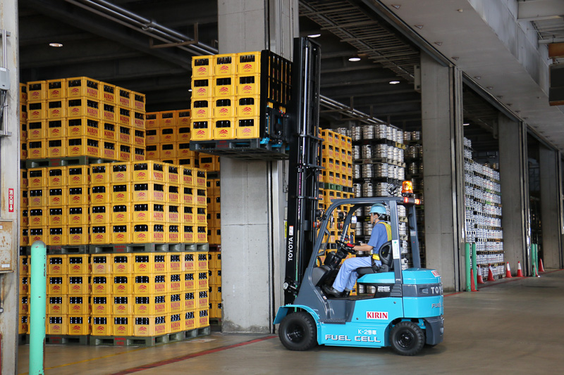 FCフォークリフトの稼動デモでは、2台のFCフォークリフトがくるくると軽快にウイングトラックの周囲を走りまわり、パレットに載せられたビールケースを次々とウイングトラックに運び込む姿が披露された