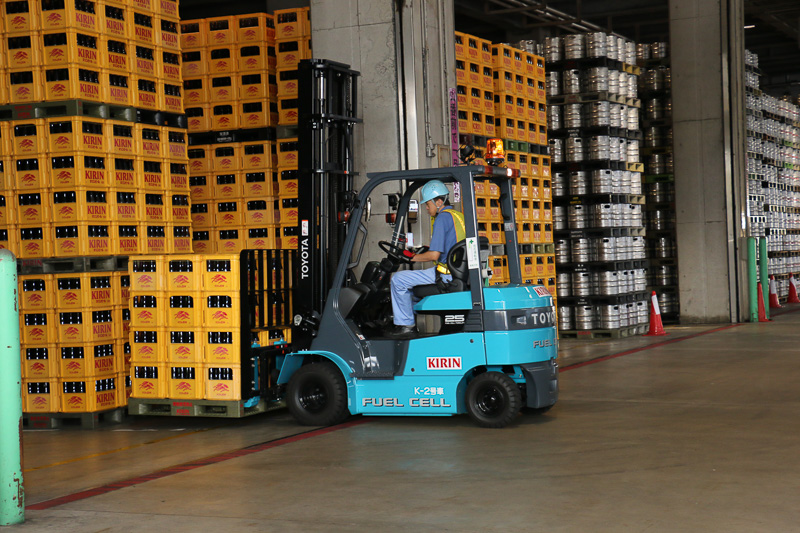 FCフォークリフトの稼動デモでは、2台のFCフォークリフトがくるくると軽快にウイングトラックの周囲を走りまわり、パレットに載せられたビールケースを次々とウイングトラックに運び込む姿が披露された