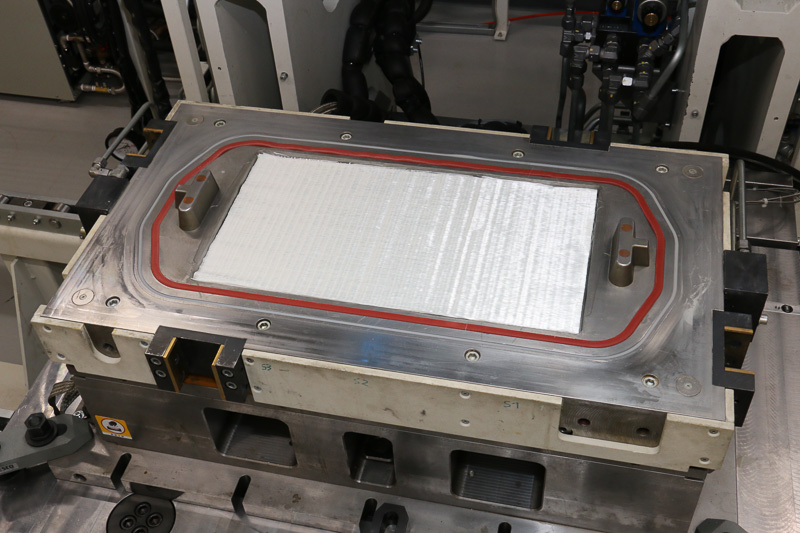 成型実演がスタート。まずはガラス繊維プリフォームを大型成形機の金型にセット