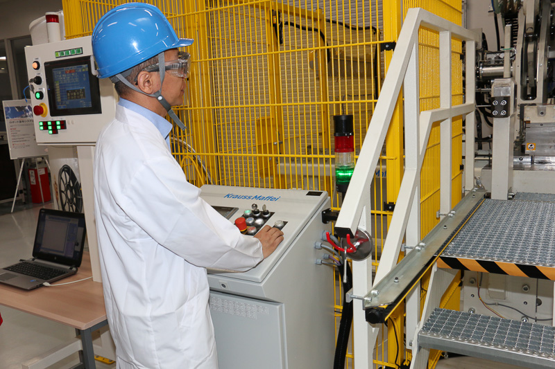 操作パネルのボタンを押して大型成形機を稼動開始