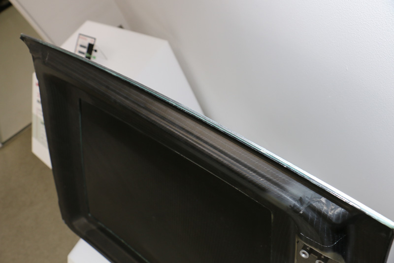 「スポーツカーの分割式ルーフ」をイメージした製品サンプル。CFRP製のルーフ部分とフレーム部分の2つを接着剤で組み合わせたもの。同じCFRPだが、平滑でそのまま塗装できるルーフ部分、立体的で強度の高いフレーム部分と使い分けている