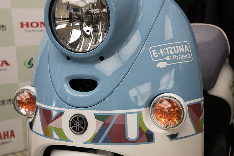 KIZUNAの文字とさいたま市の10区のイメージカラーを取り入れたグラフィックデザインをボディに設定。E-KIZUNA Projectのマークはフロント、左右カバー、シート後方に入る